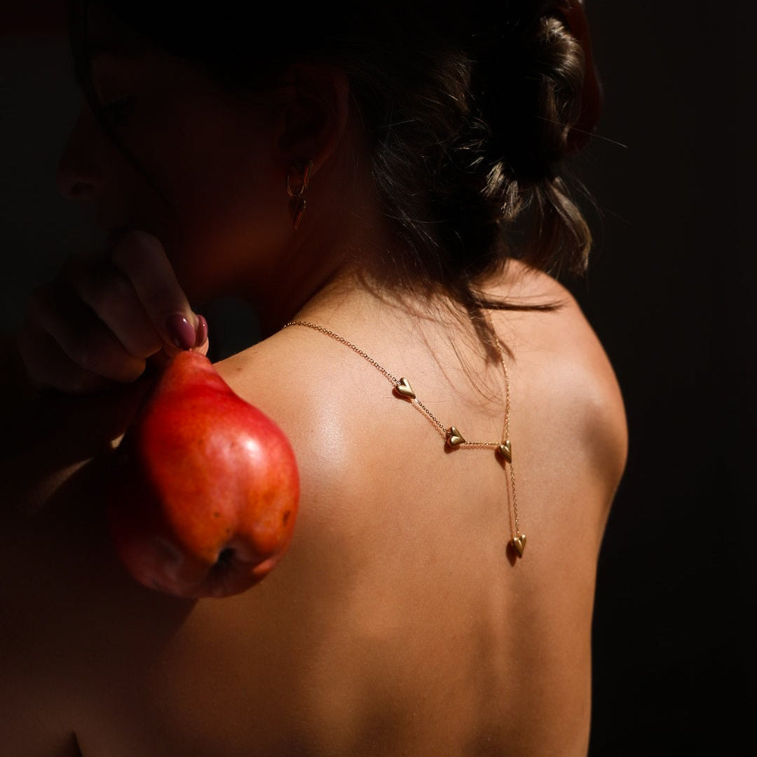 Woman holding a red apple against a dark background
