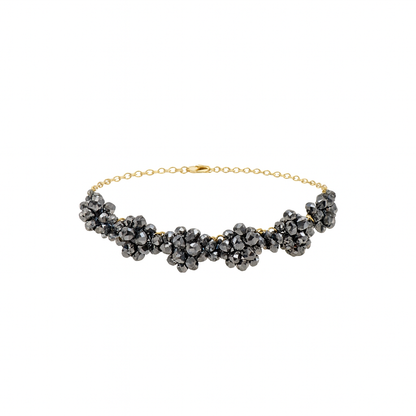Necklace with black beads and gold chain on a white background
