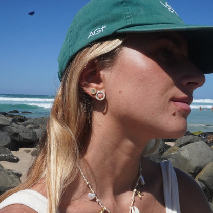 Close-up of a person wearing a necklace with a blue sky and rocky background