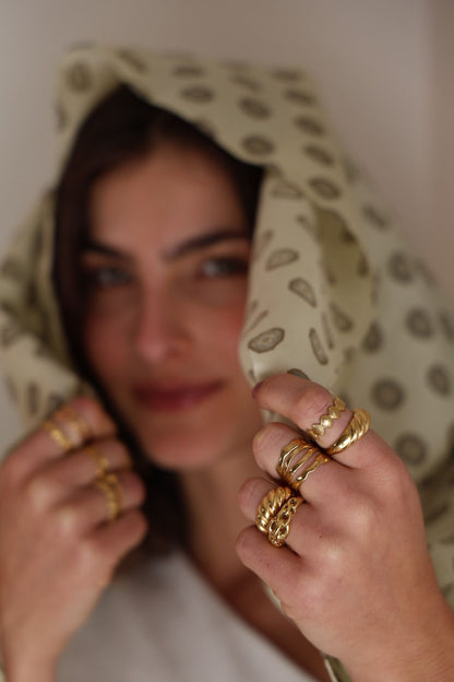 Woman wearing gold rings with a patterned headscarf